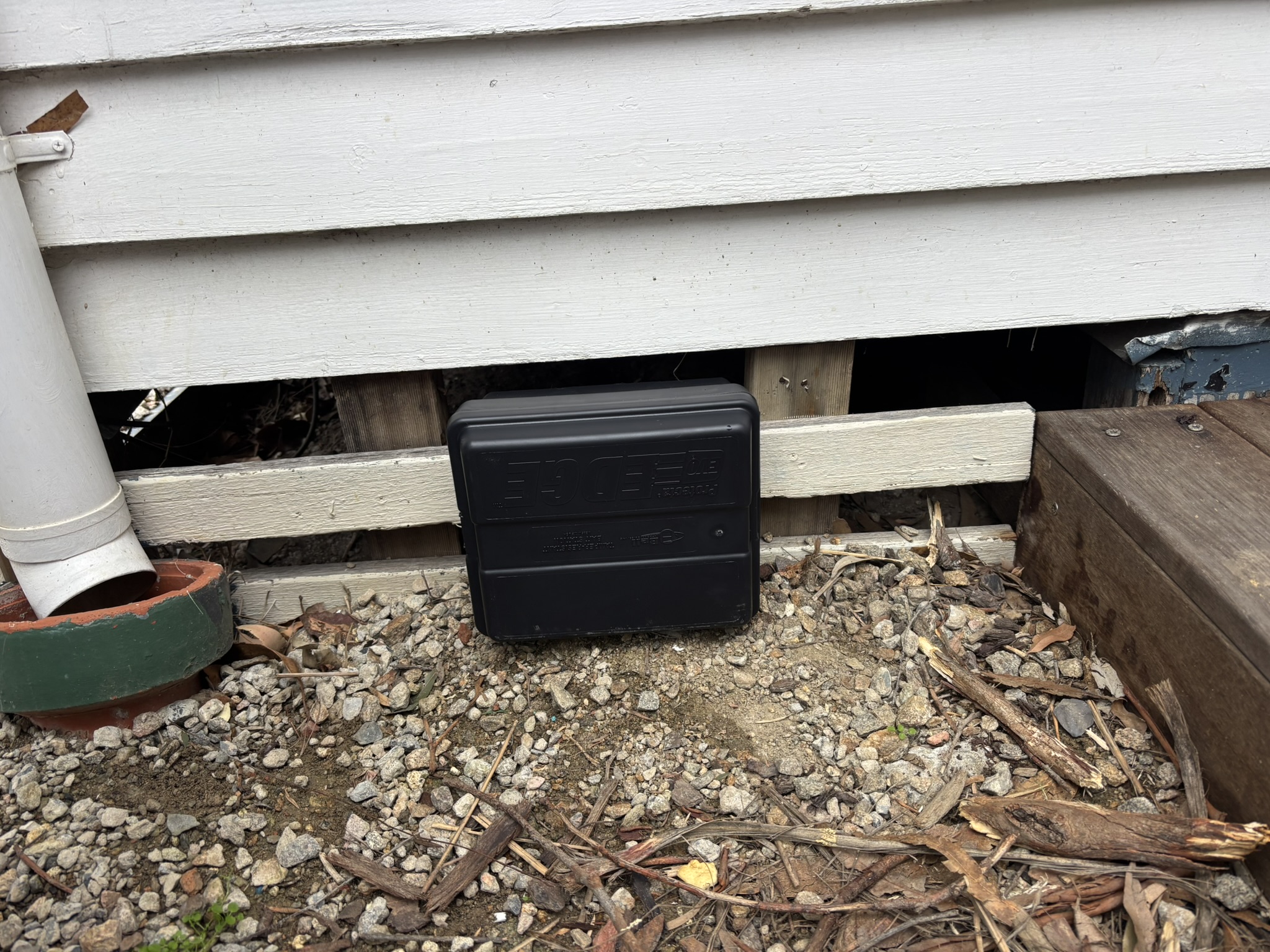 Mouse bait station installed along wall for safe rodent control